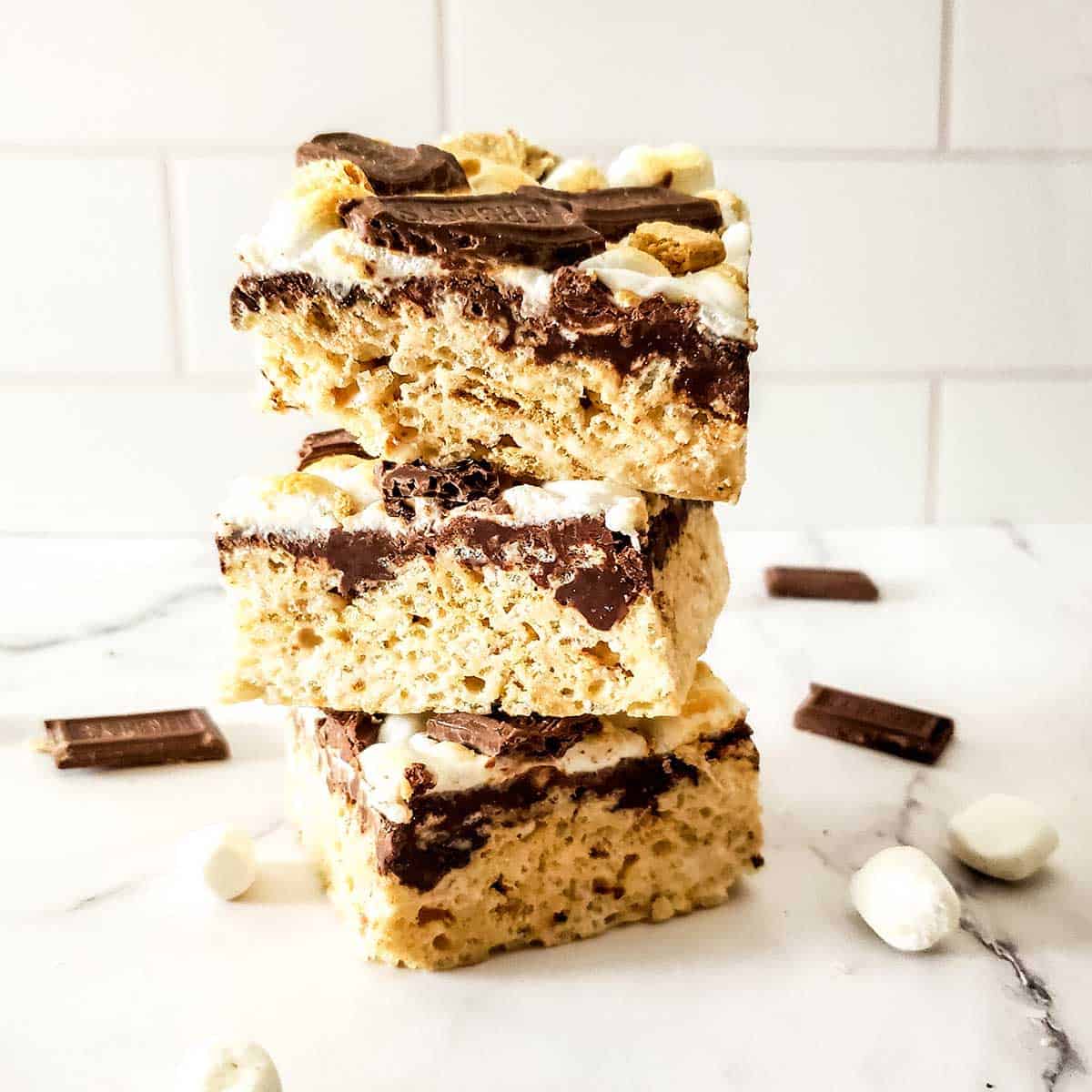 Stack of cooled s'mores rice krispie bars on counter.
