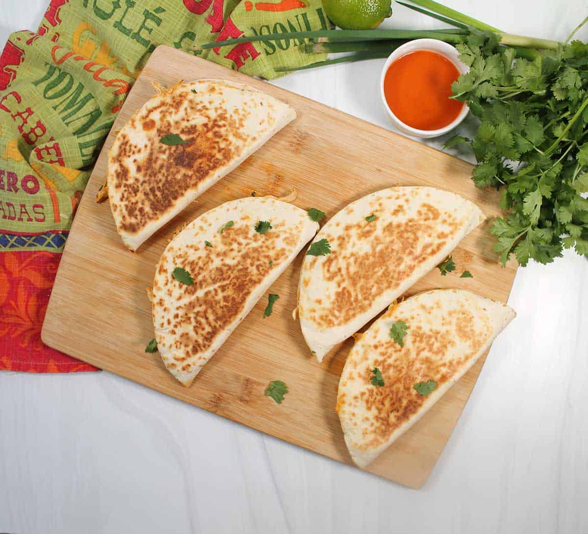 Cooked quesadillas on cutting board.