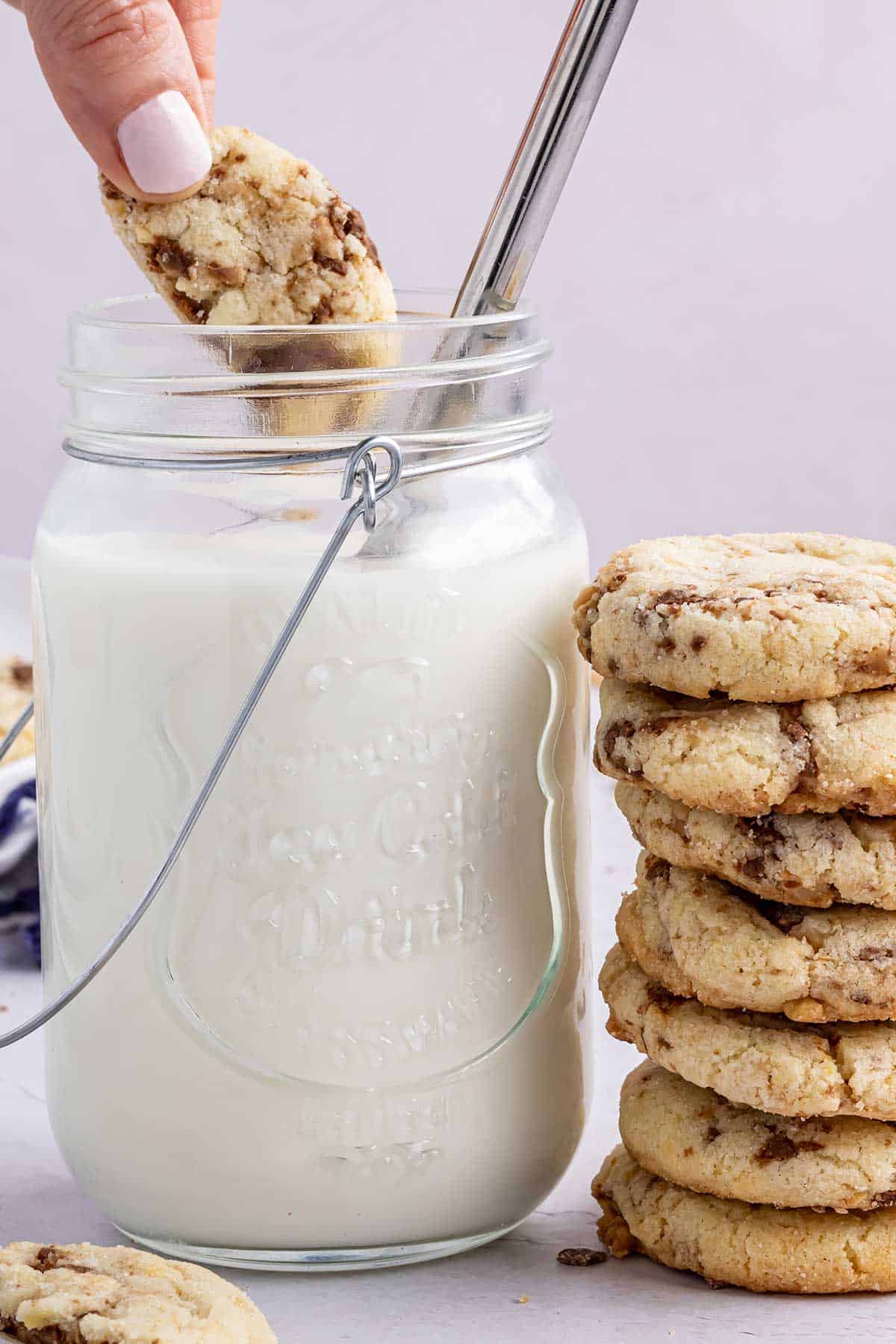 Dipping toffee cookie into milk.