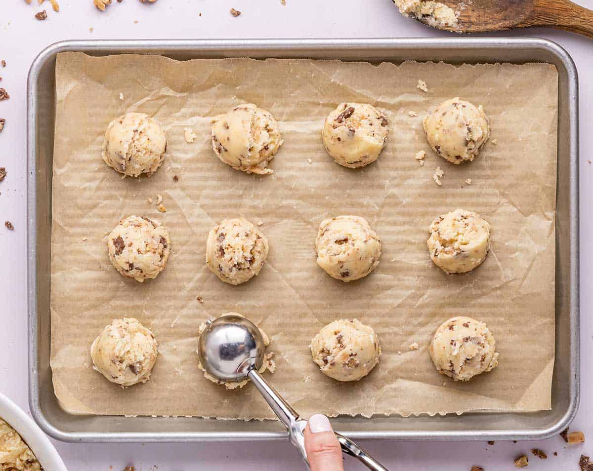 Scooping cookie dough onto baking sheet.