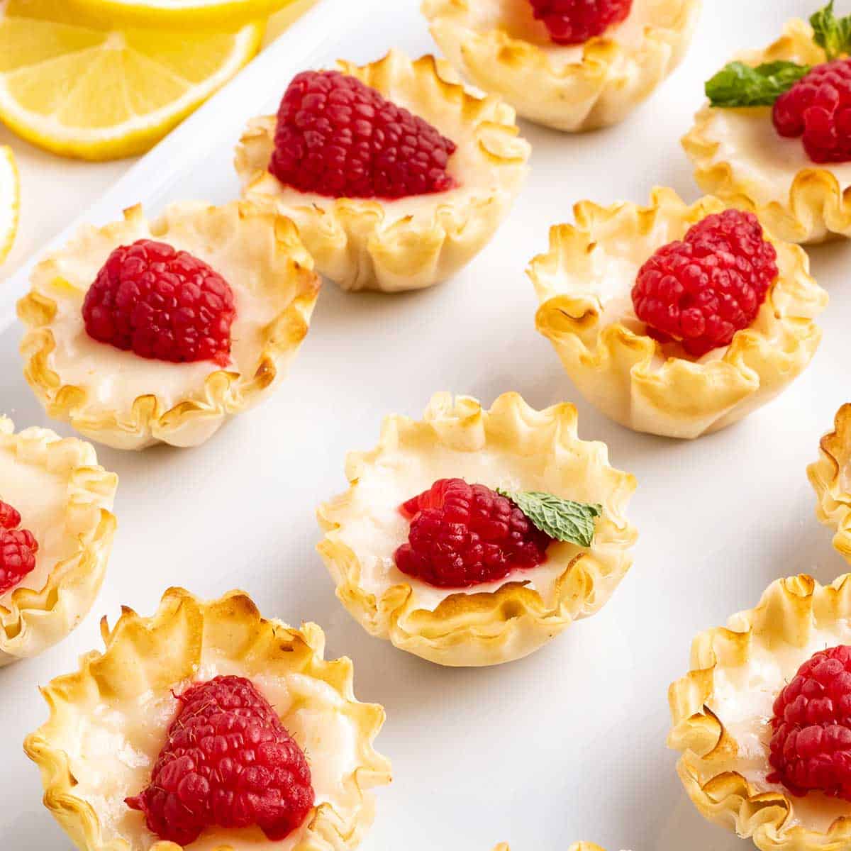 Berry topped tarts lined up.