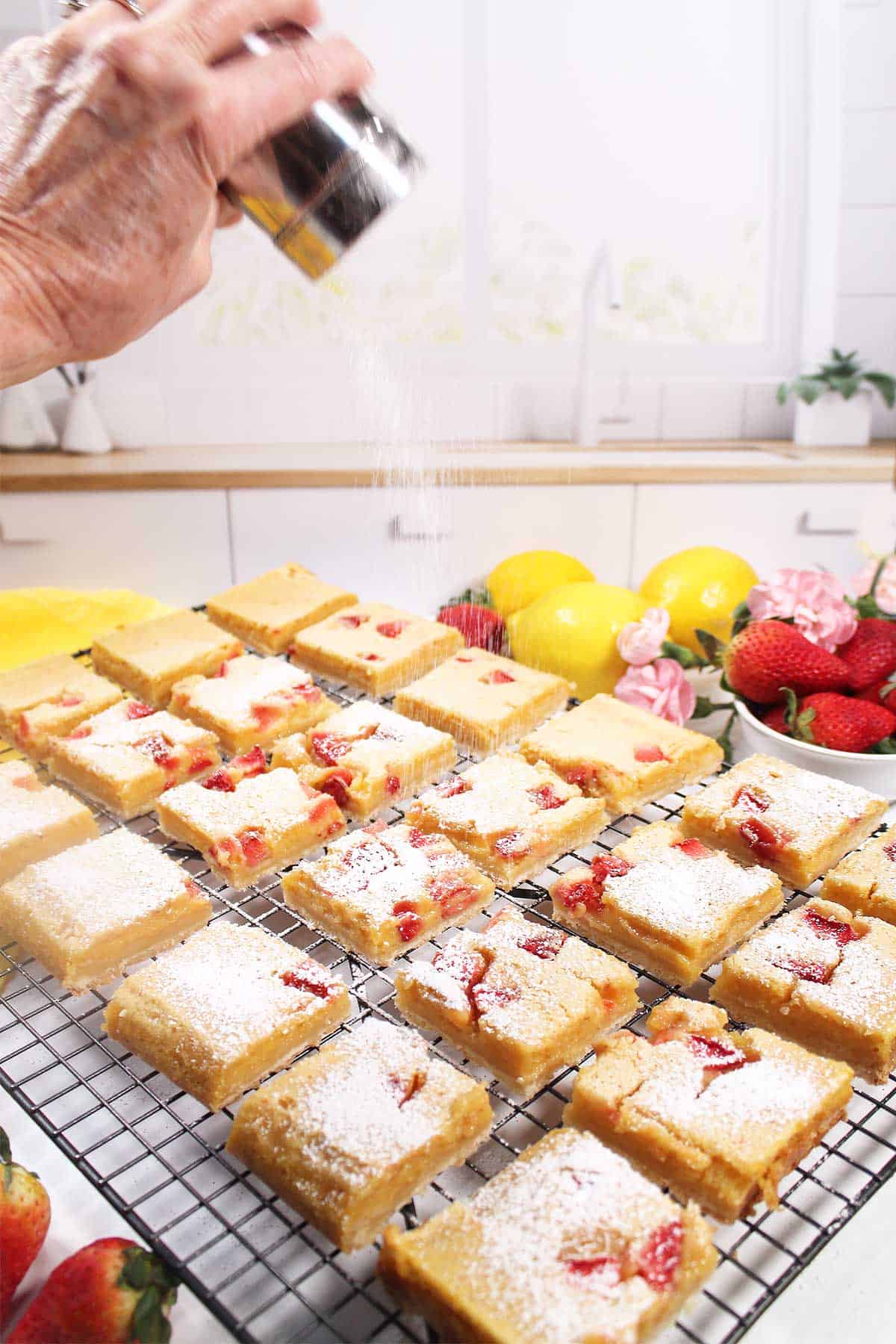 Sprinkling the cookie bars with powdered sugar.