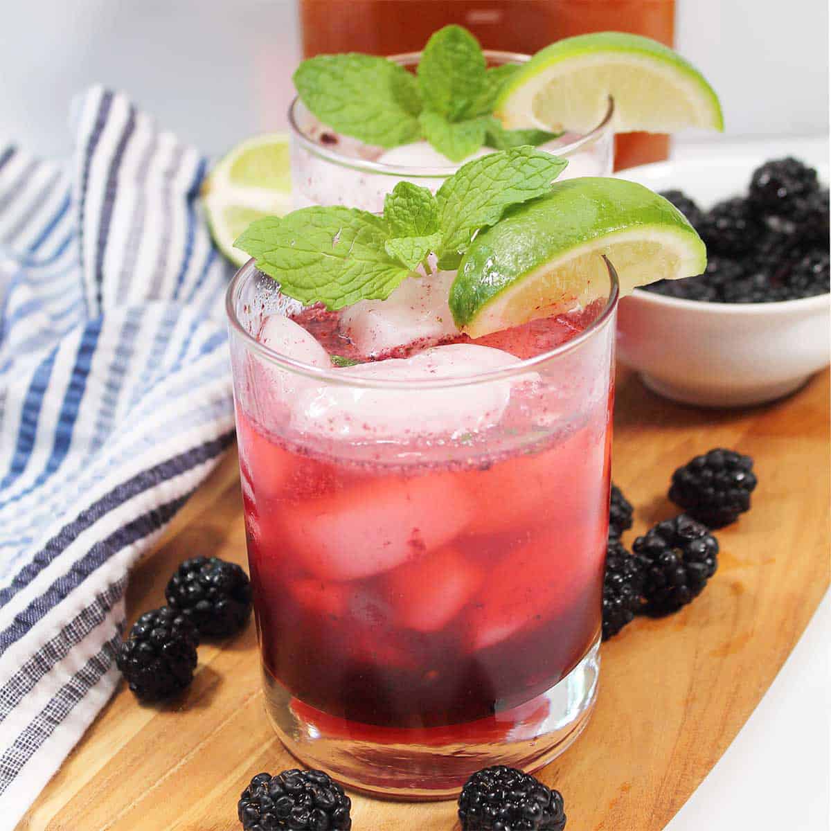 Two garnished blackberry bourbon smash cocktails.