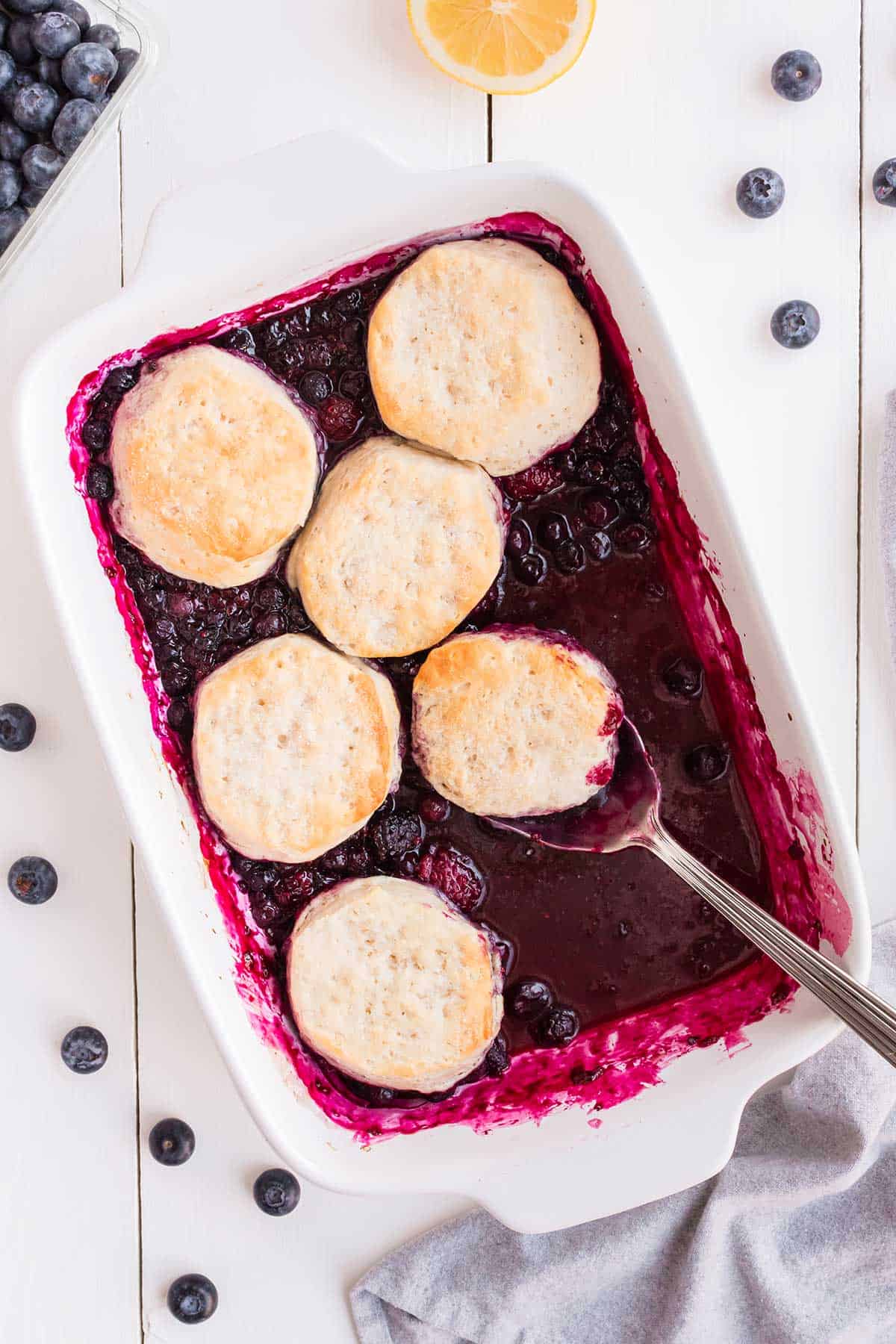 Spooning out serving of fruit cobbler.