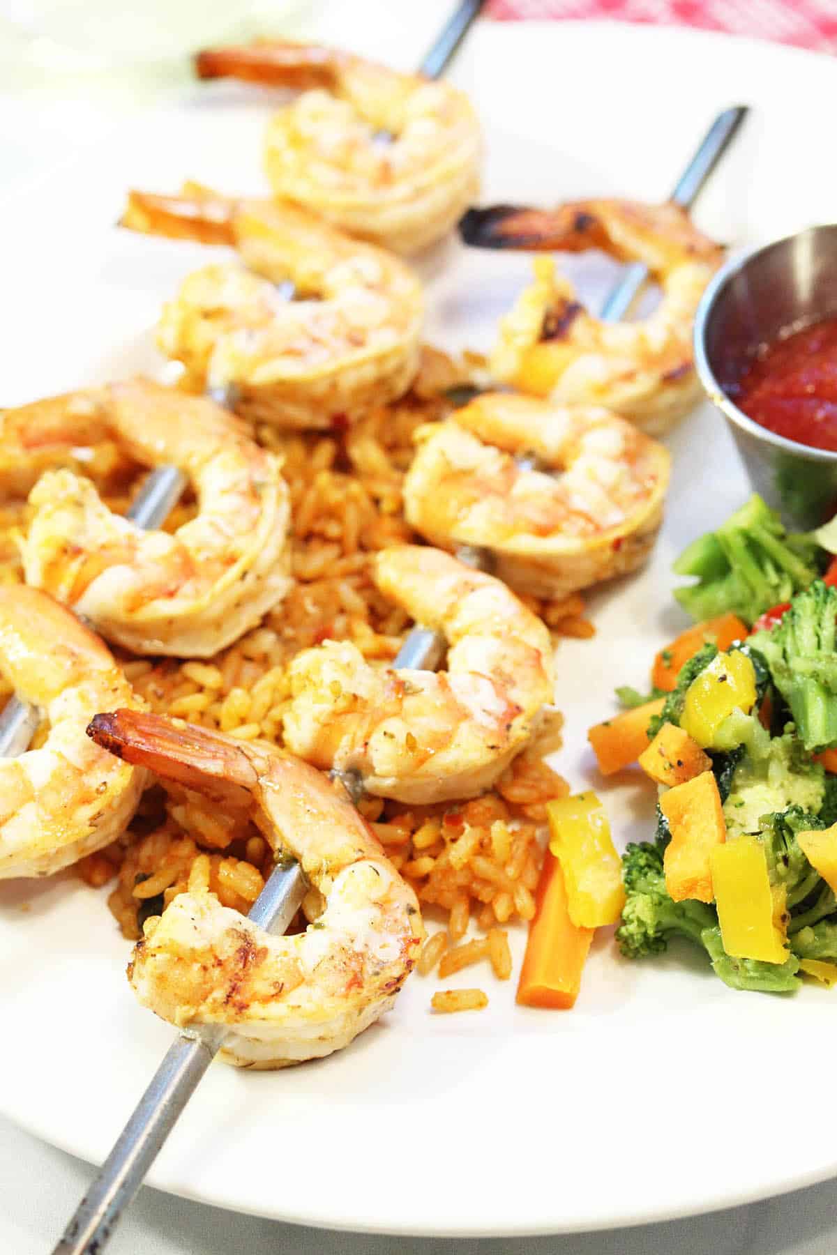 Grilled shrimp plated over rice dinner.