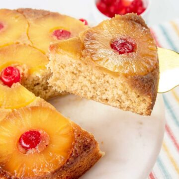 Lifting slice of cake from whole upside down cake.