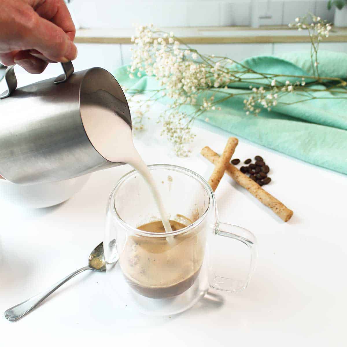 Pouring foamed milk into espresso.