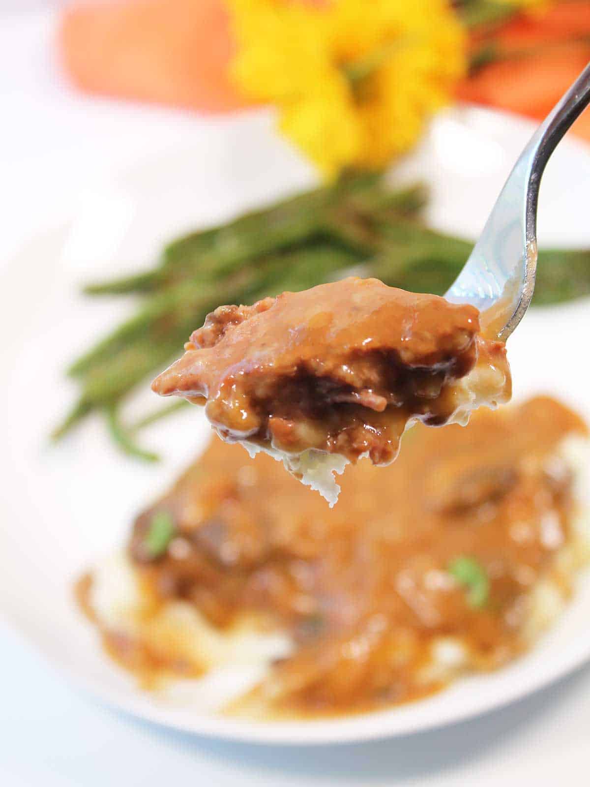 Bite of cube steak on fork.