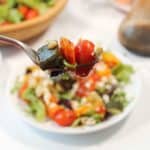 Bite of salad on fork.