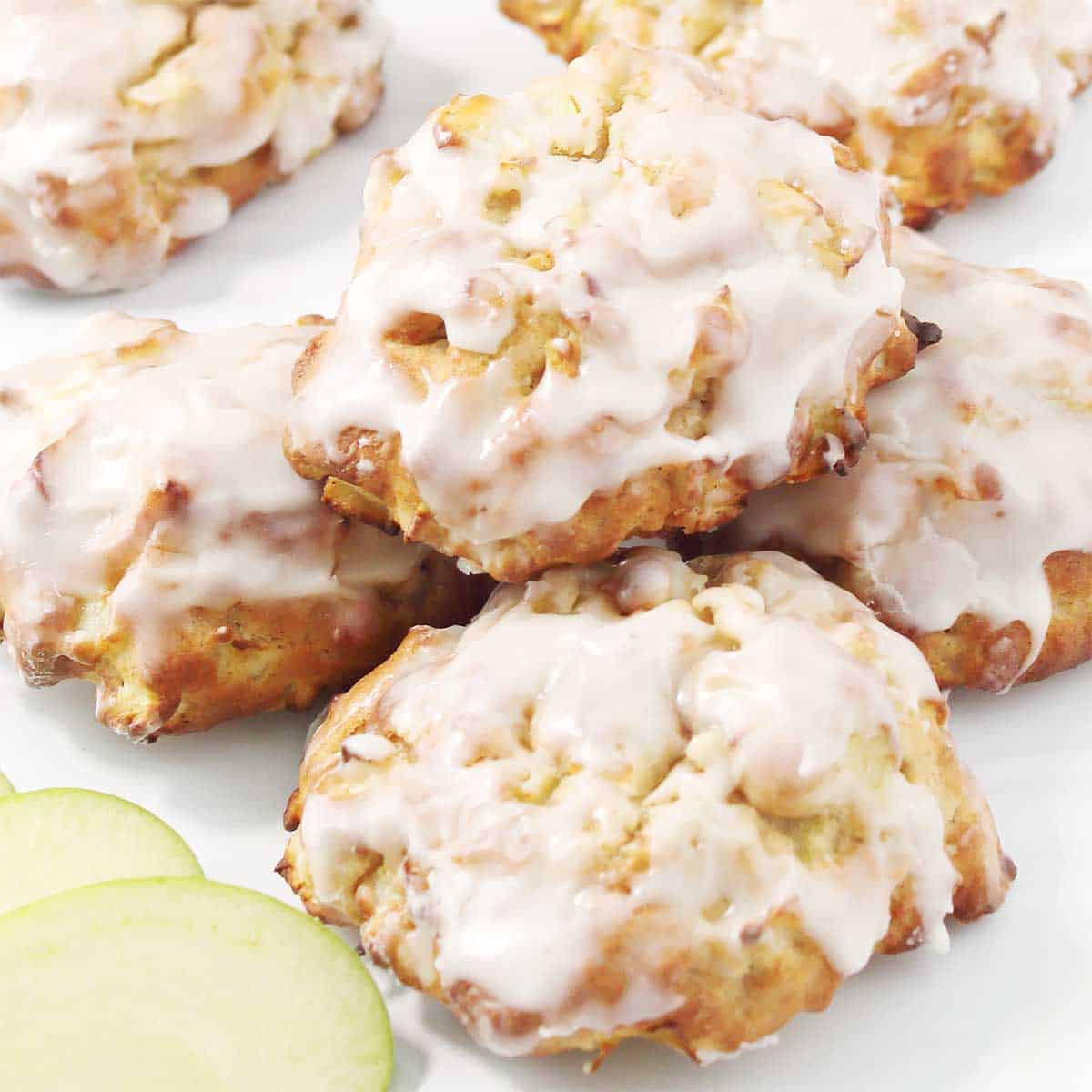 Stacked air fryer apple fritters with apple slices.