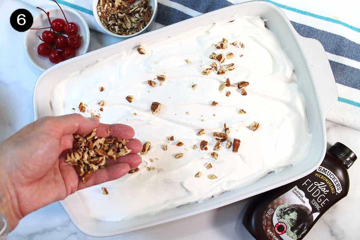 Sprinkling nuts over cool whip.