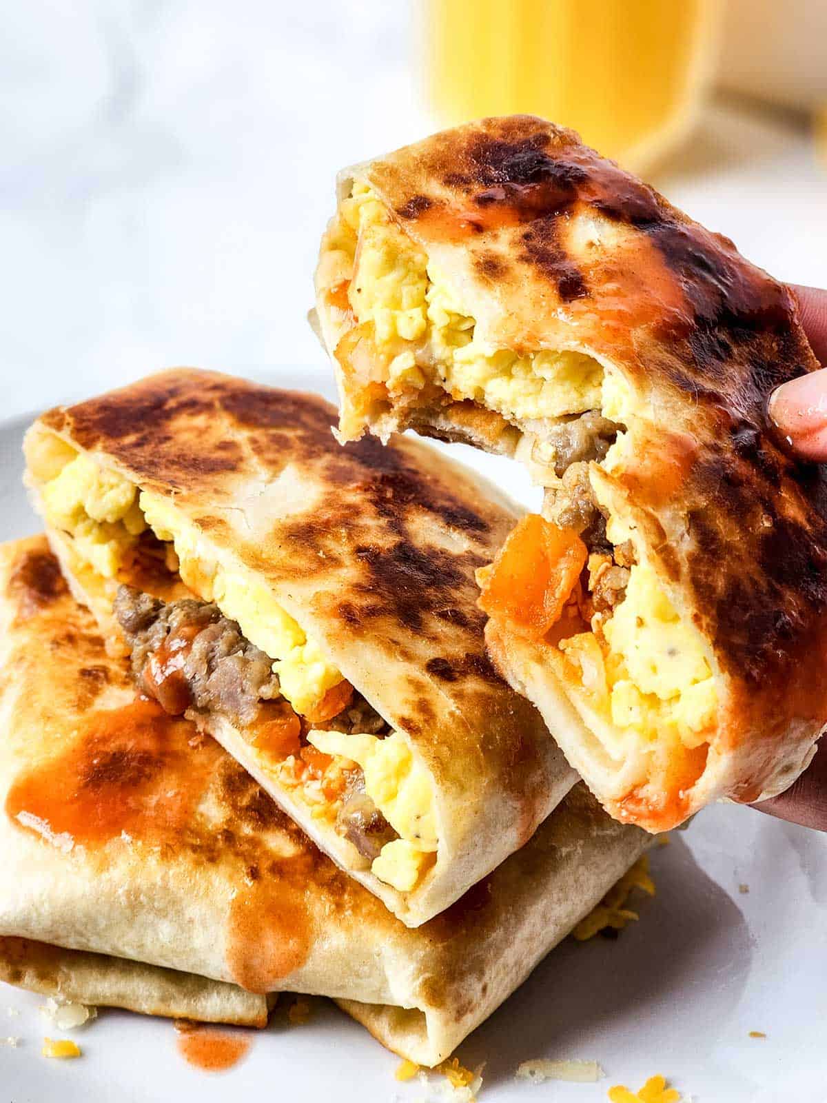 Holding breakfast wrap with bite taken out.