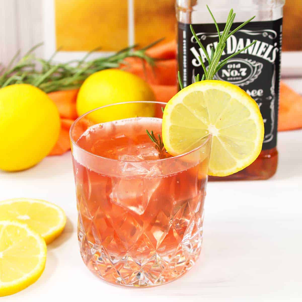 Cranberry Whiskey Sour with lemon and rosemary garnish.