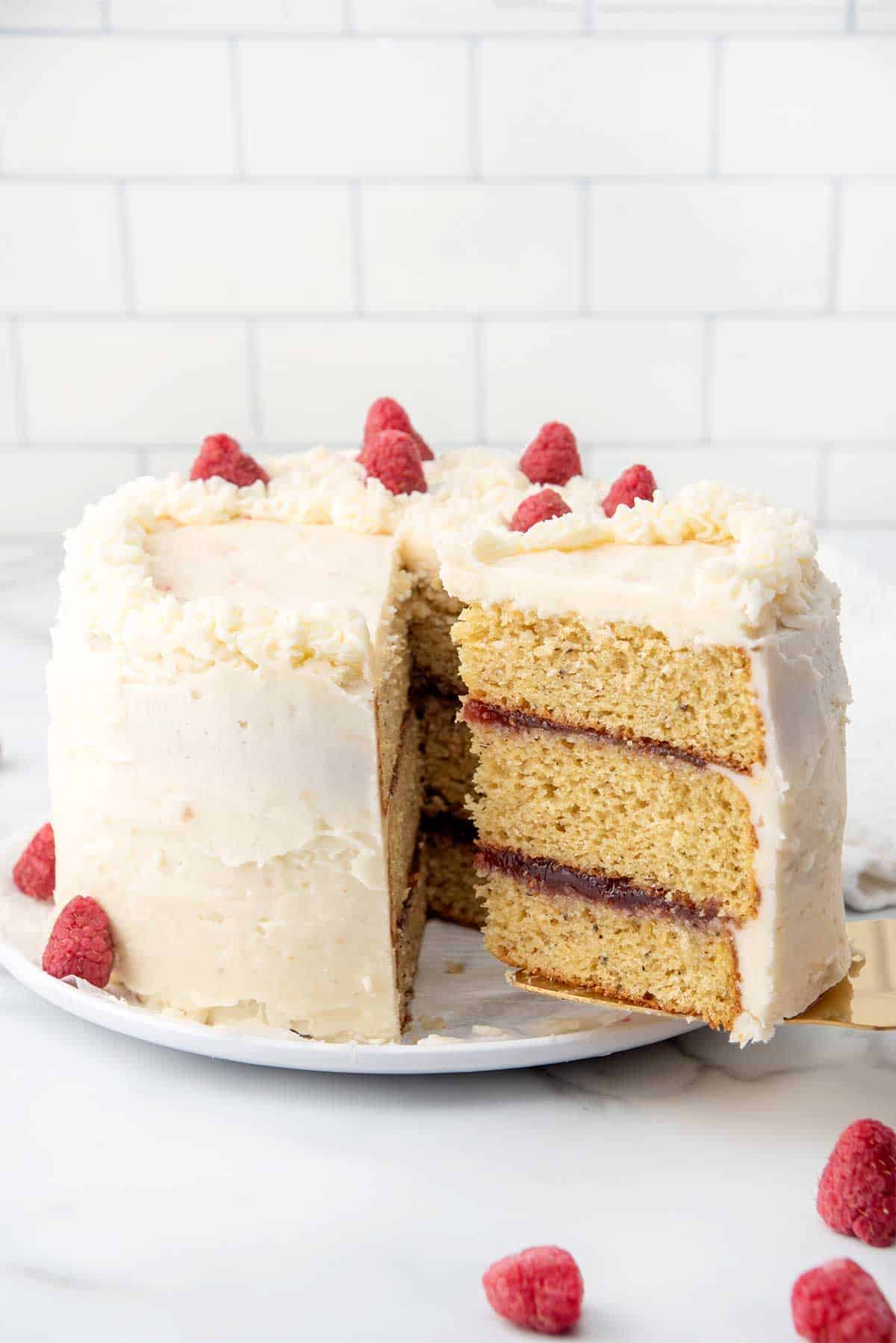 Lifting slice of earl grey cake from frosted and decorated cake.