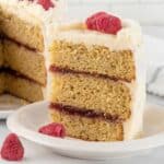 Closeup of slice of cake layered with raspberry jam.