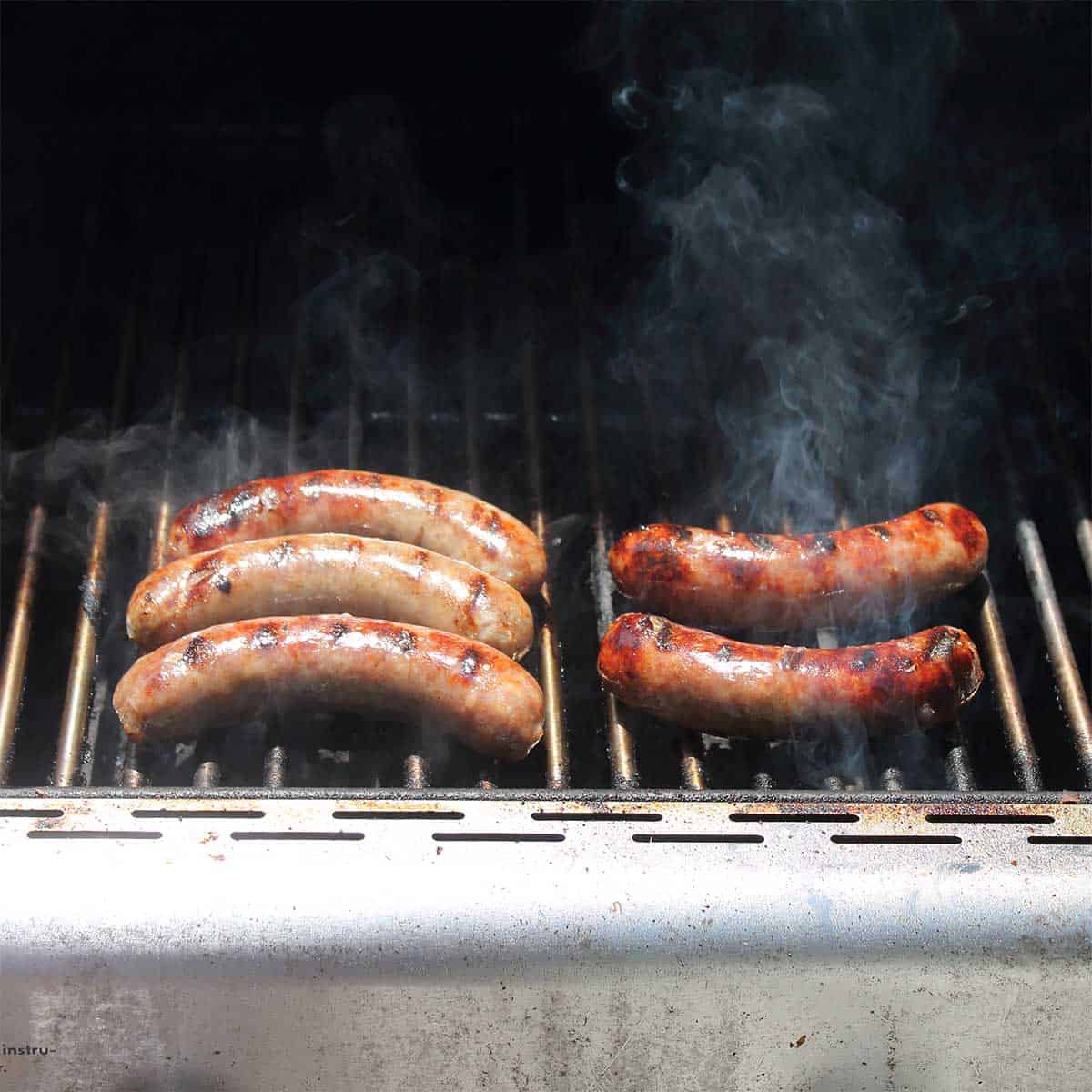 Bratwurst cooking on grill.