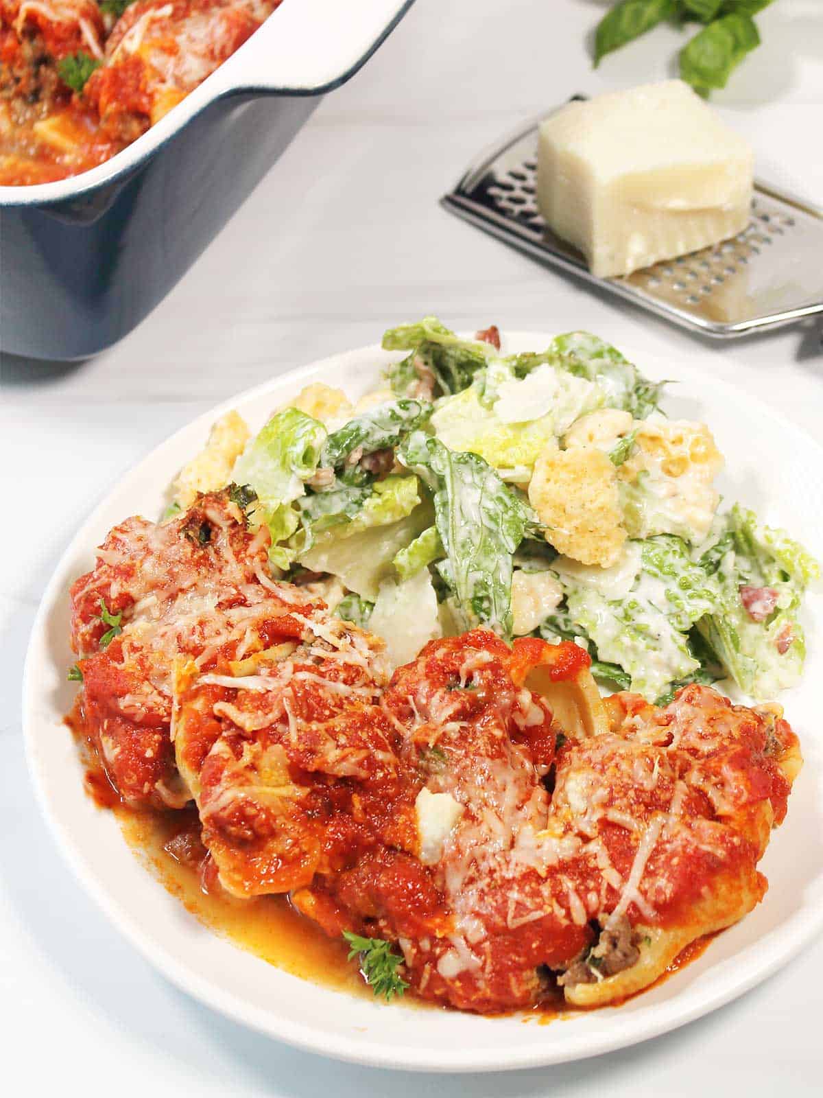 Beef stuffed shells plated with salad.