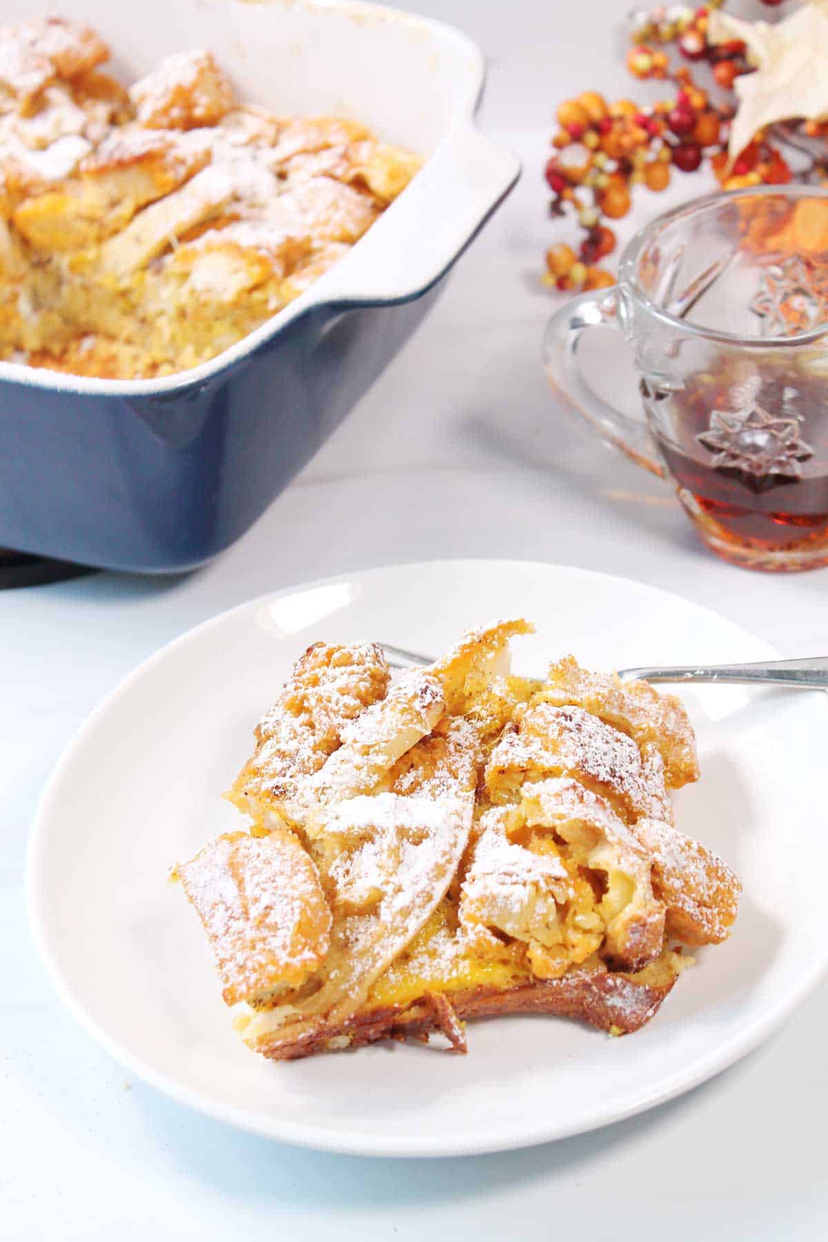 Plated serving of fried chicken and waffles in front of casserole.