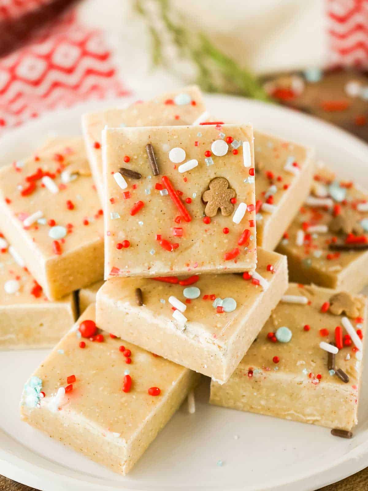 Condensed milk fudge with sprinkles stacked on plate.