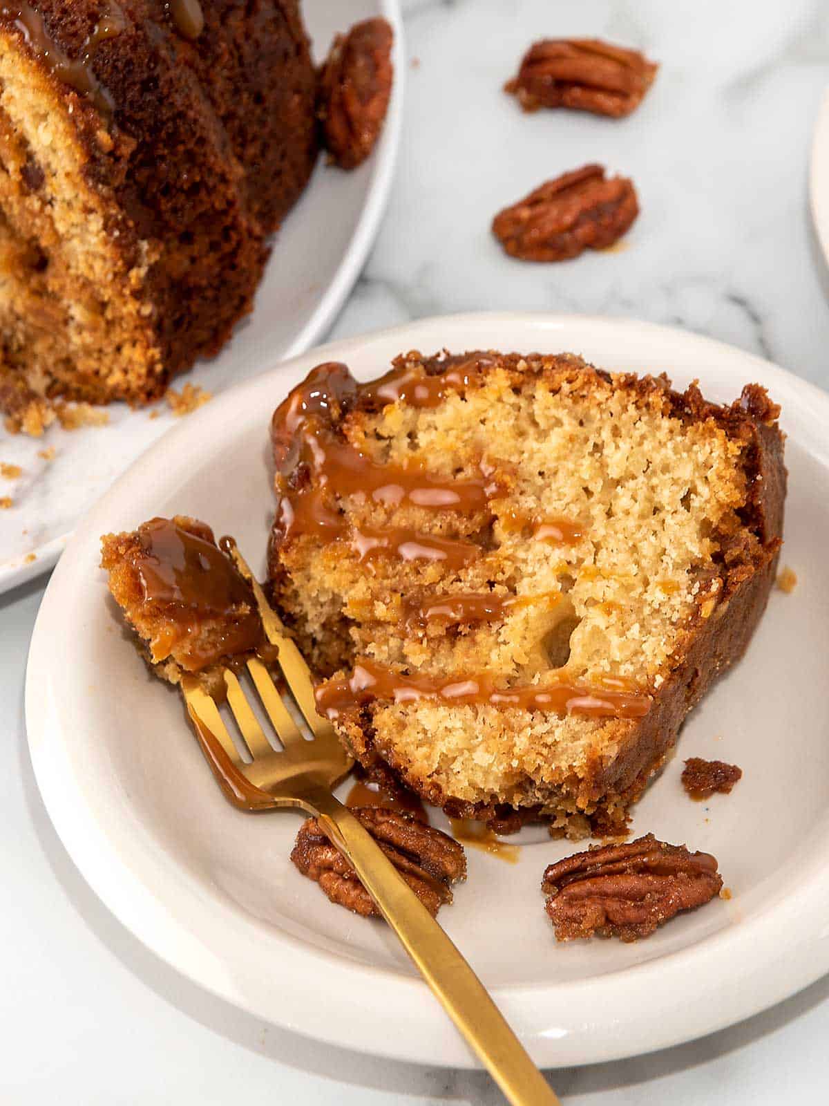 Slice of pound cake on plate with bite on fork.