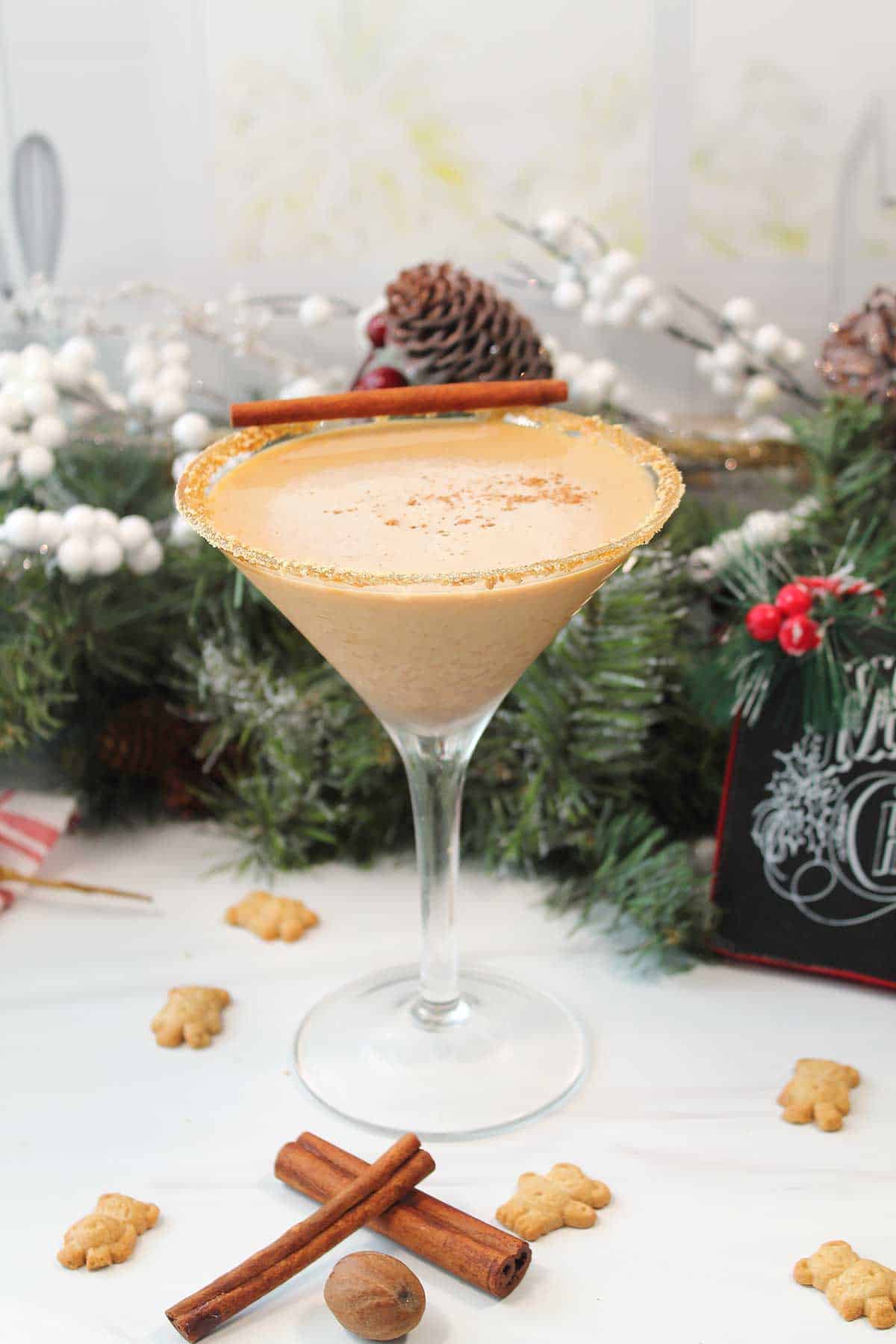 Gingerbread Martini on table with cinnamon sticks and gingerbread men.