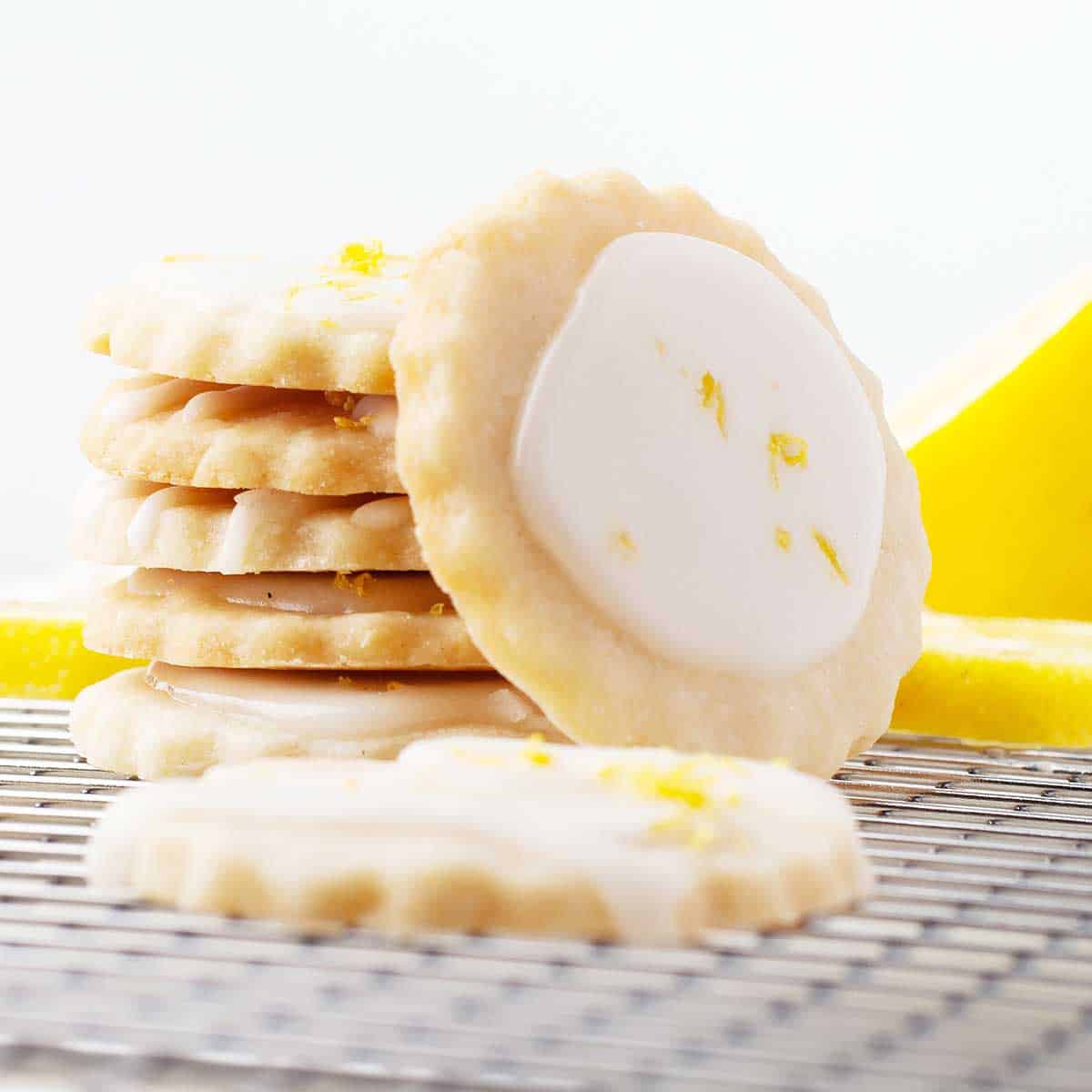 Stacked Lemon Shortbread Cookies with one cookie leaning on stack.