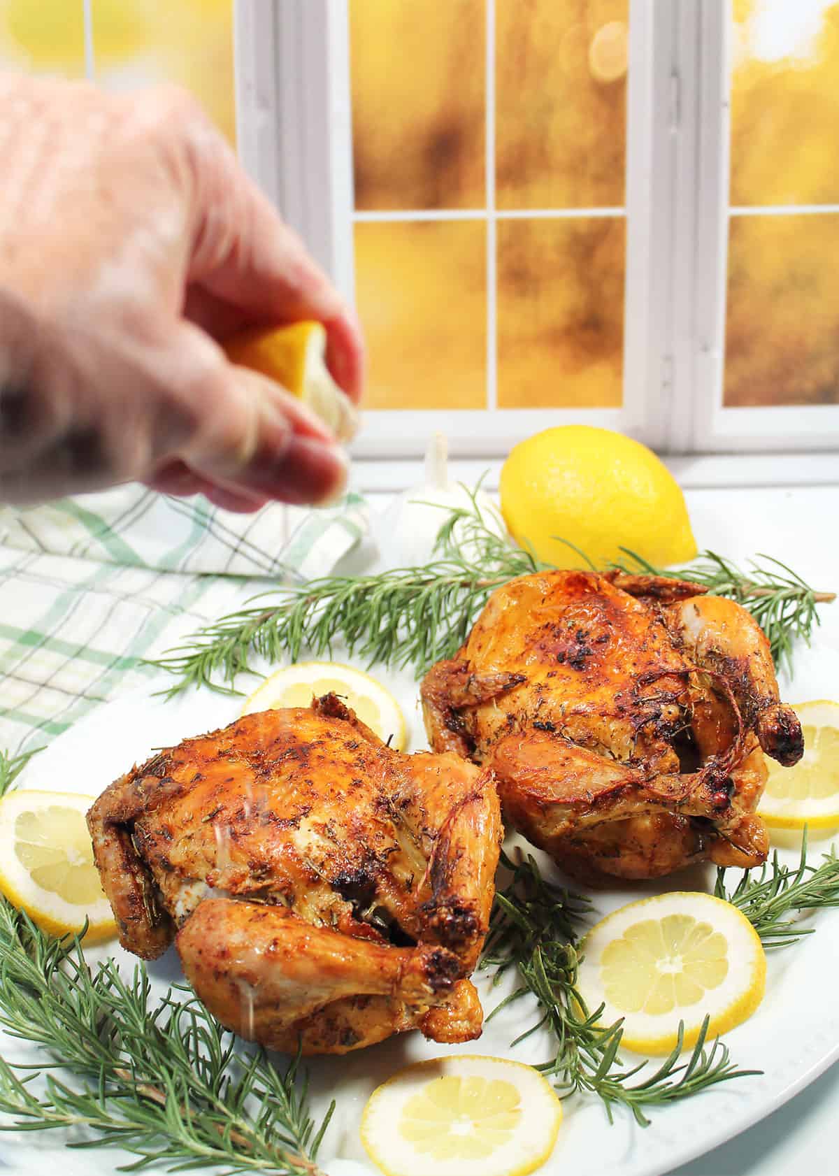 Squeezing lemon over air fried Cornish hens.