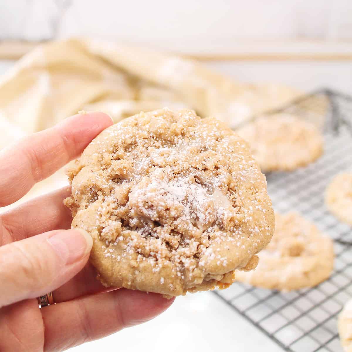 Holding cookie showing crumbs and icing.
