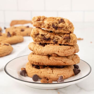 Closeup stack of cookies with one halved on top.