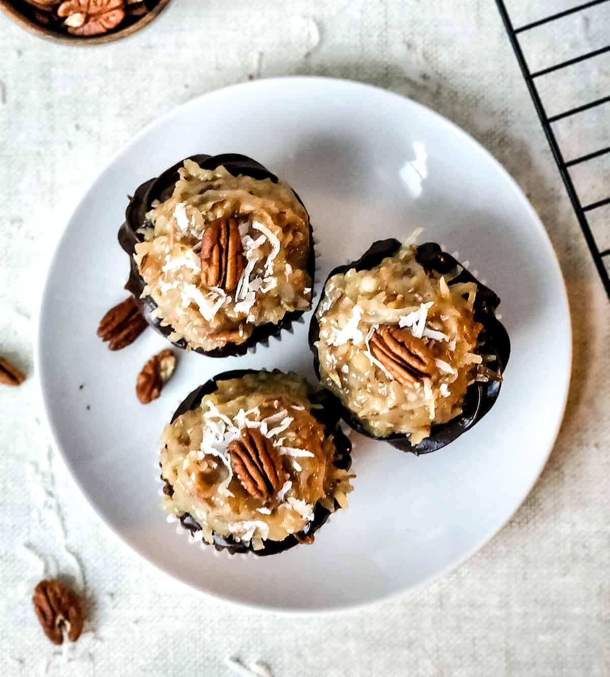 Overhead of three chocolate cupcakes on a plate.