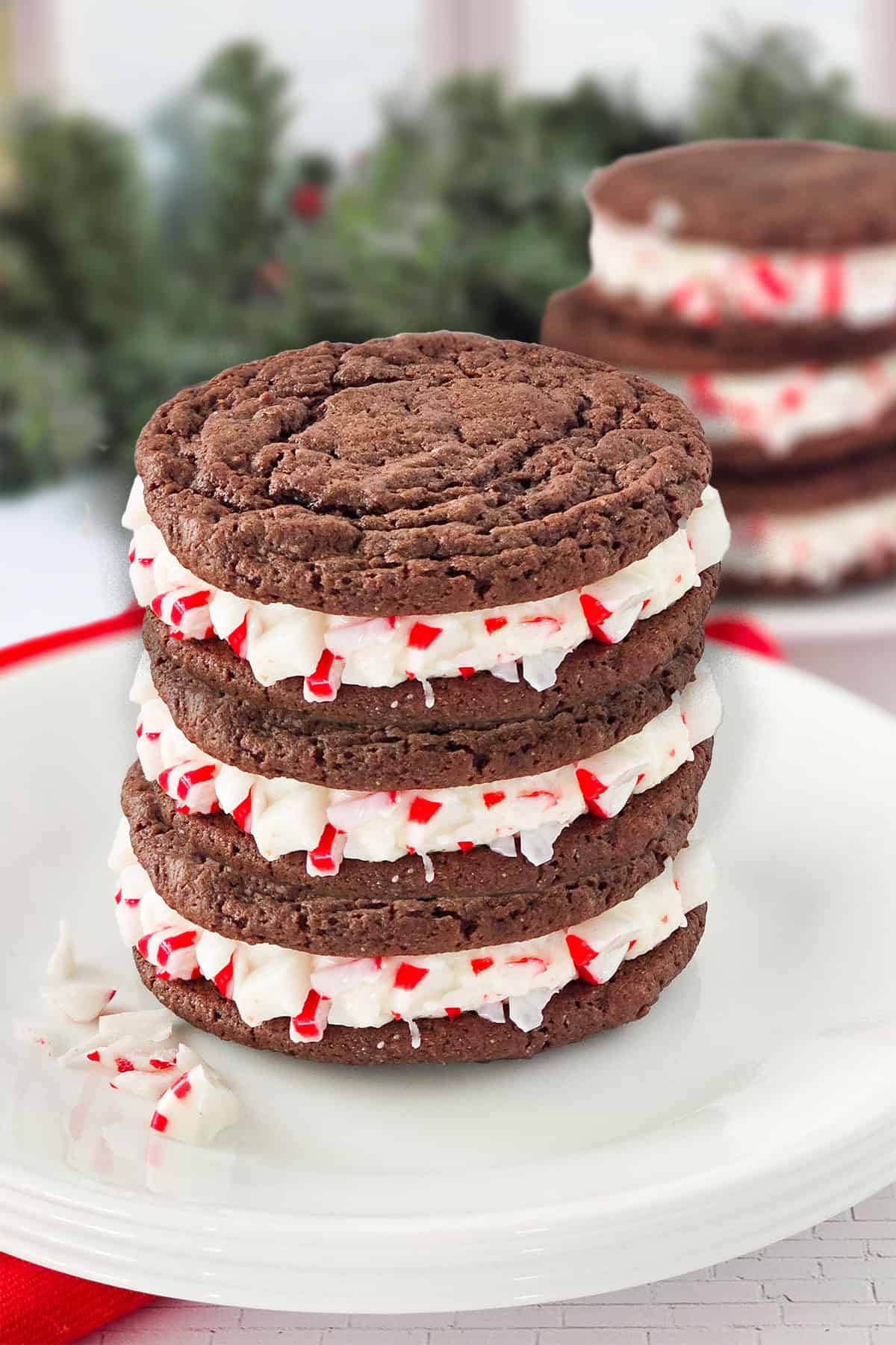 Peppermint Oreo Cookies stacked in front of greenery.