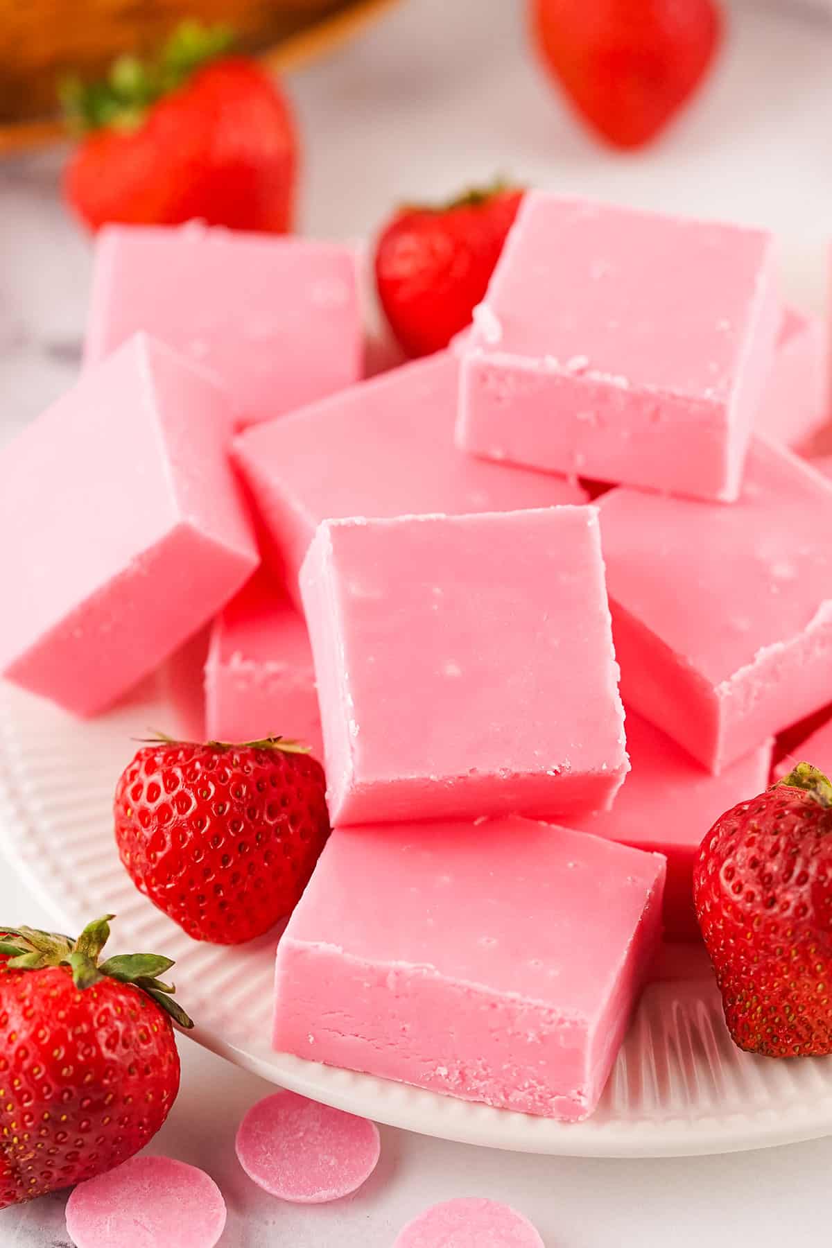 Strawberry Fudge stacked on plate with strawberries.