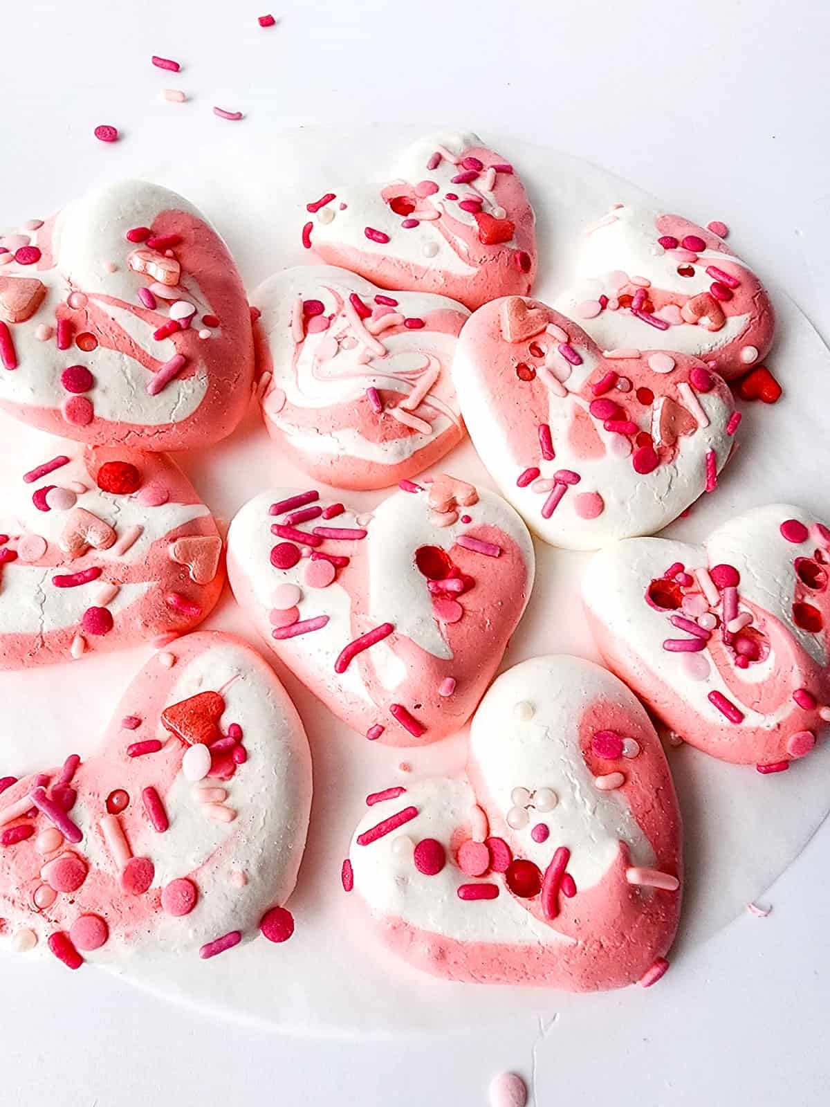 Valentines Soft Meringue Cookies scattered on table.