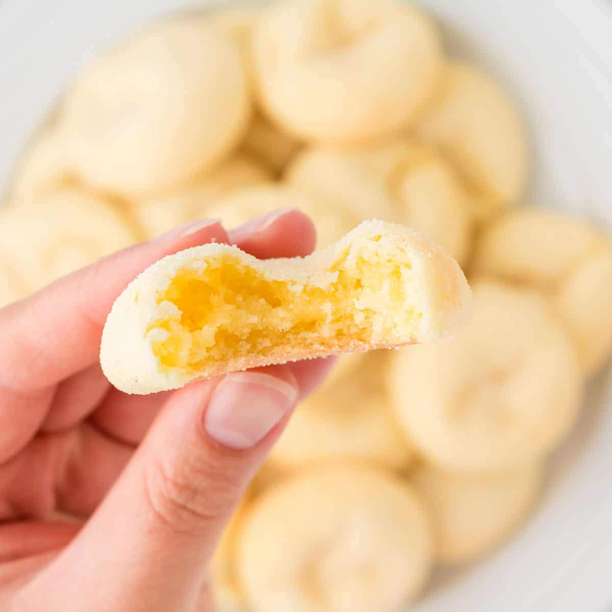 Holding cake mix cookie with bite out.