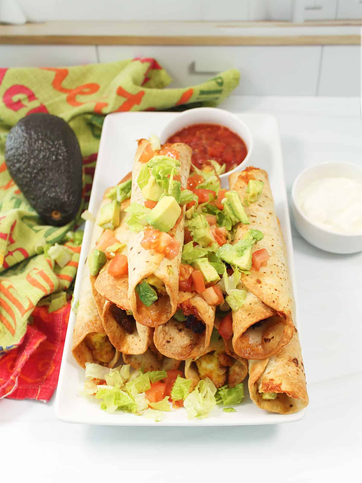 Air Fryer Breakfast Taquitos on platter with garnish.