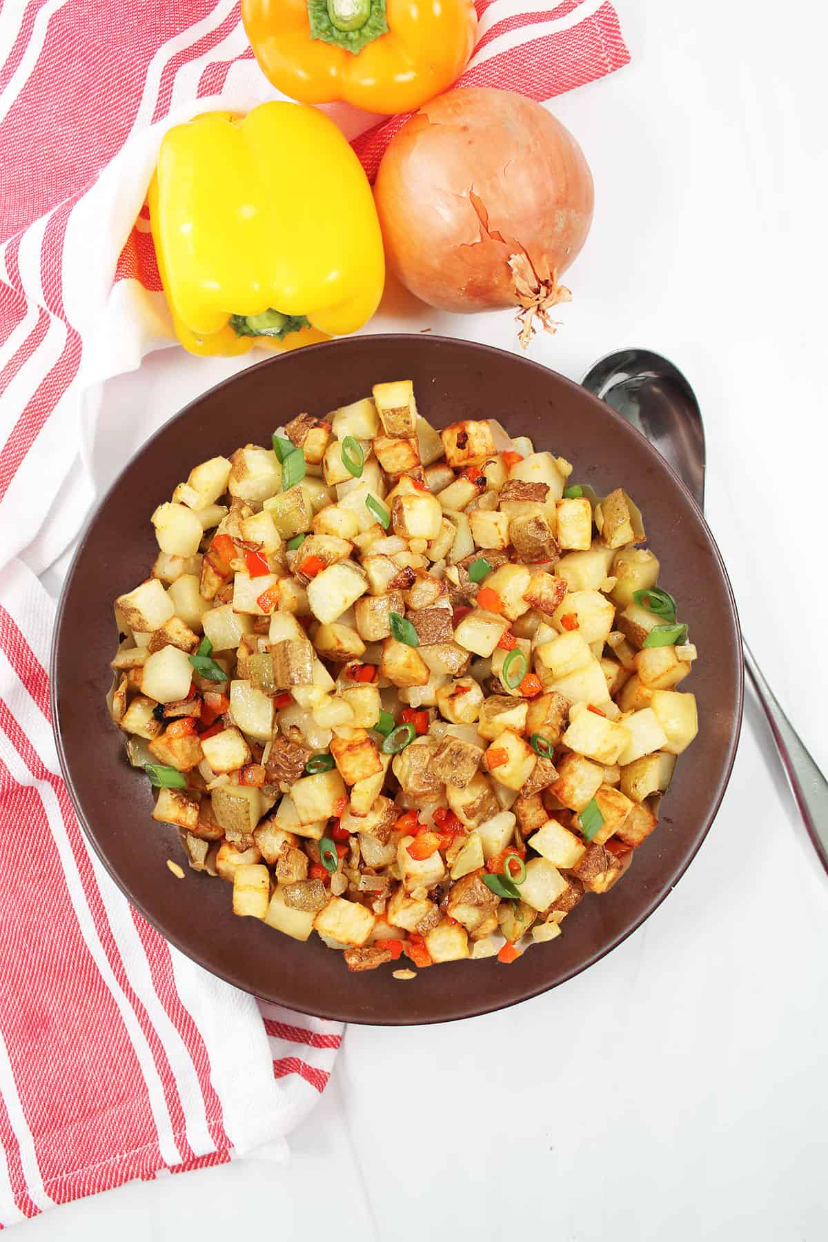 Air fryer home fries in brown serving bowl.