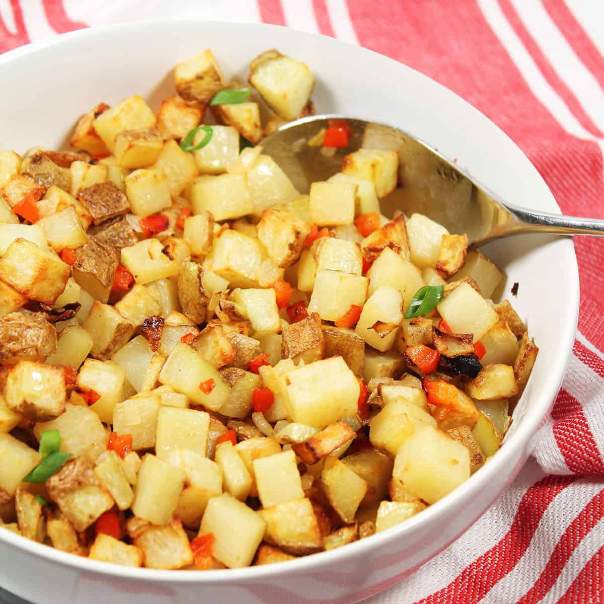 Air Fryer Home Fries in bowl with serving spoon.