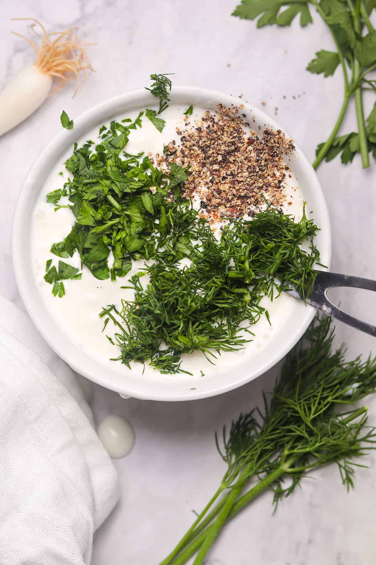 Mixing dressing ingredients in bowl.