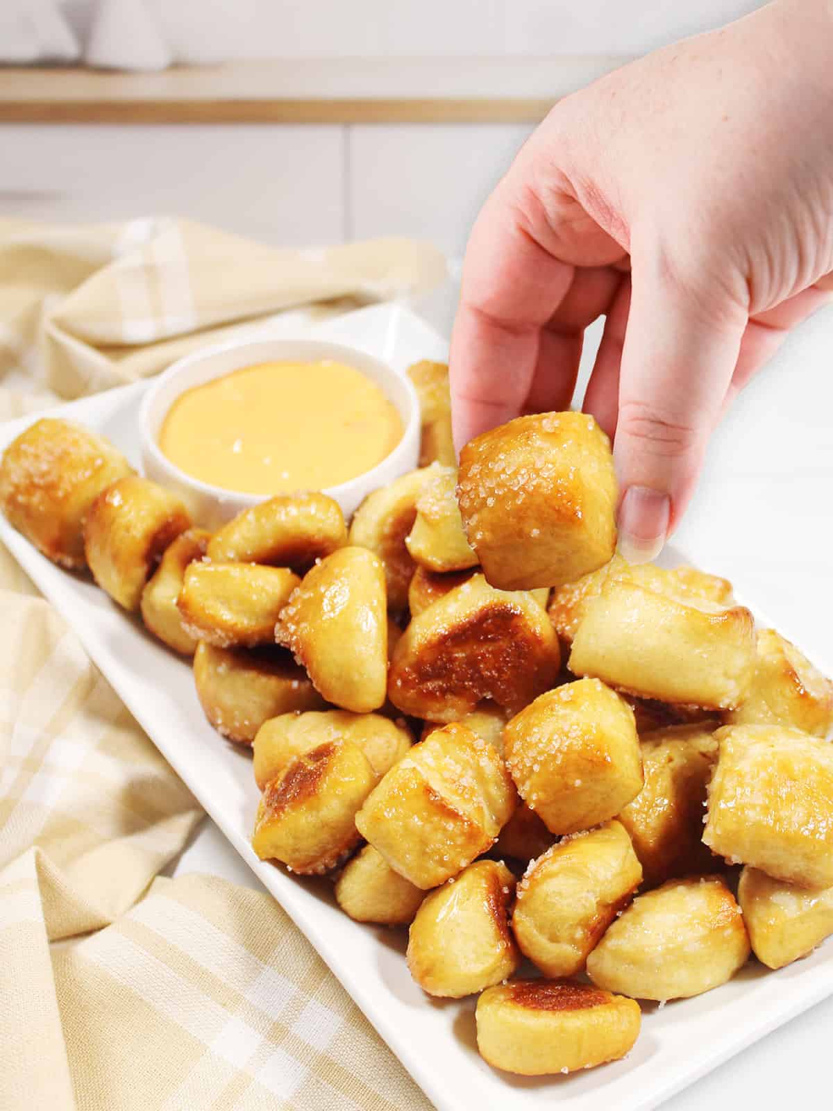 Picking up a pretzel bite.