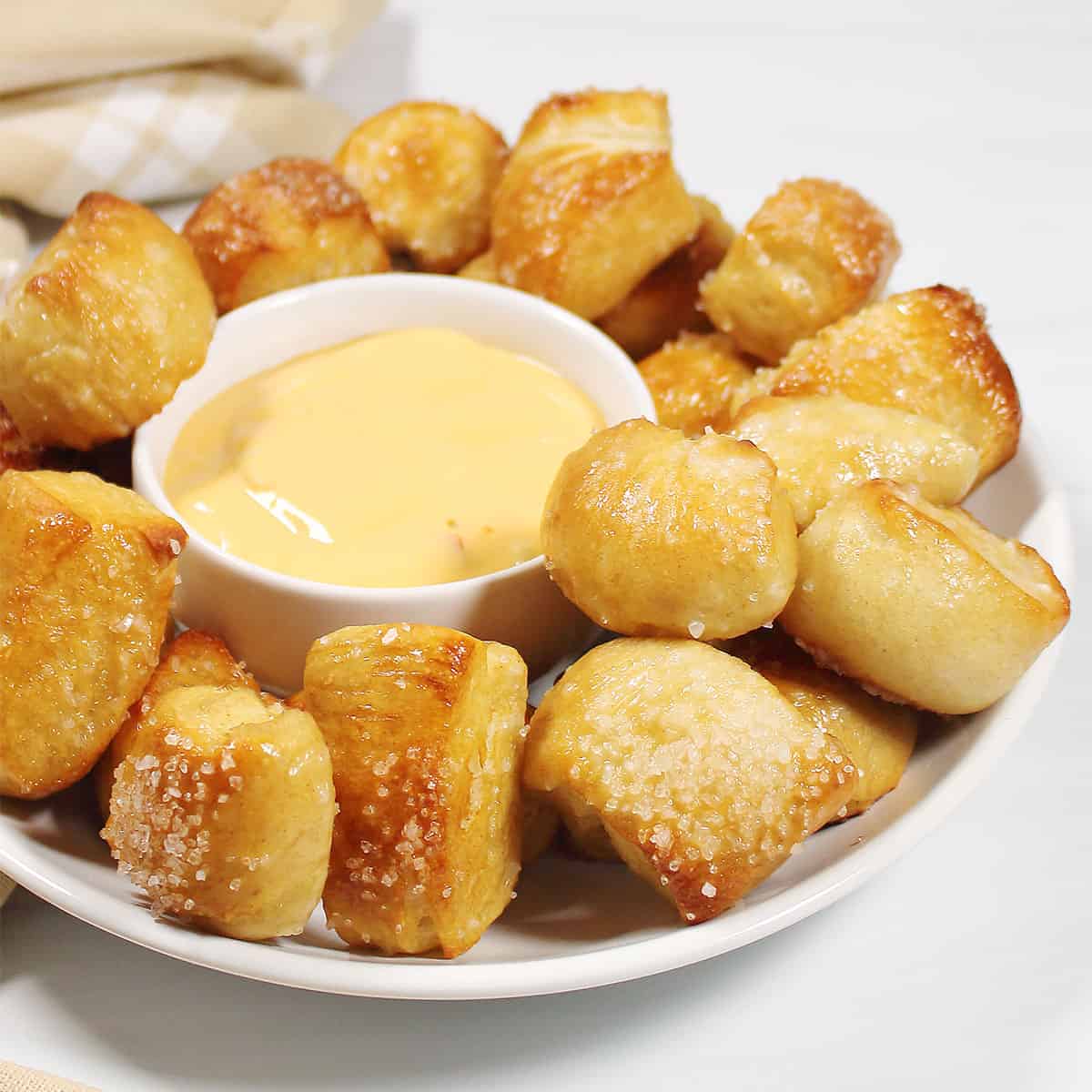 Soft pretzel bites surrounding cheese dip.