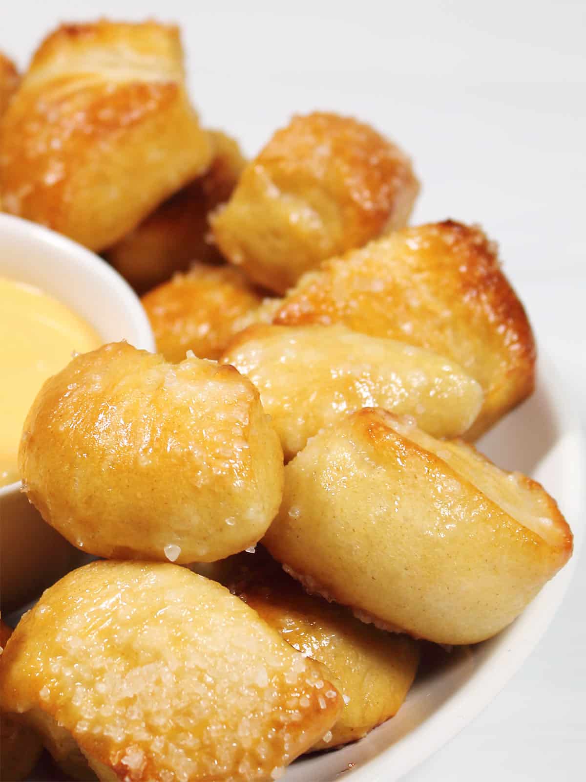 Closeup of pretzel bites surrounding dip.