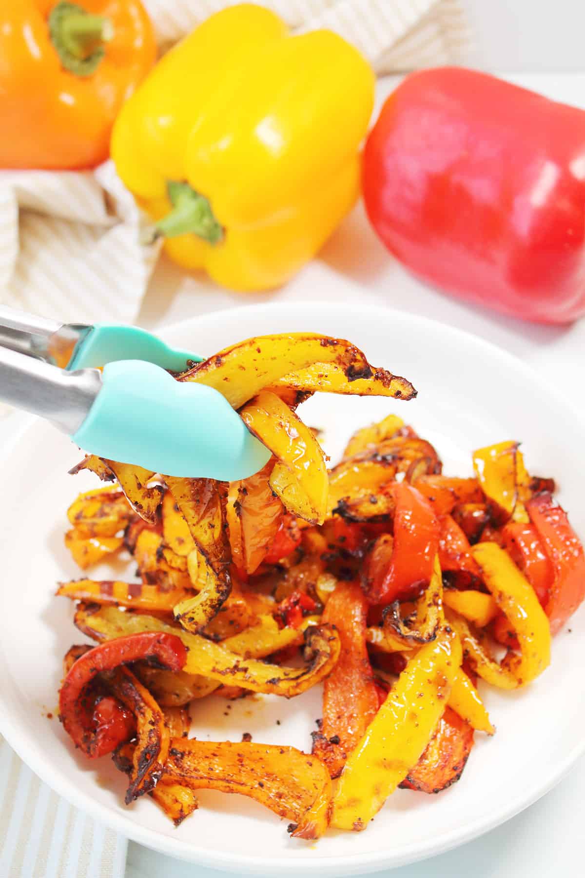 Grabbing Air Fryer Peppers with tongs.