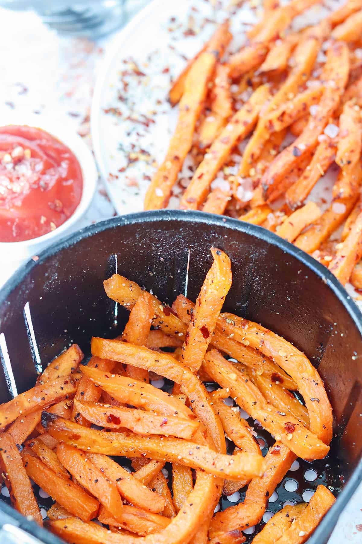 Air fried crispy sweet potatoes in air fryer basket.