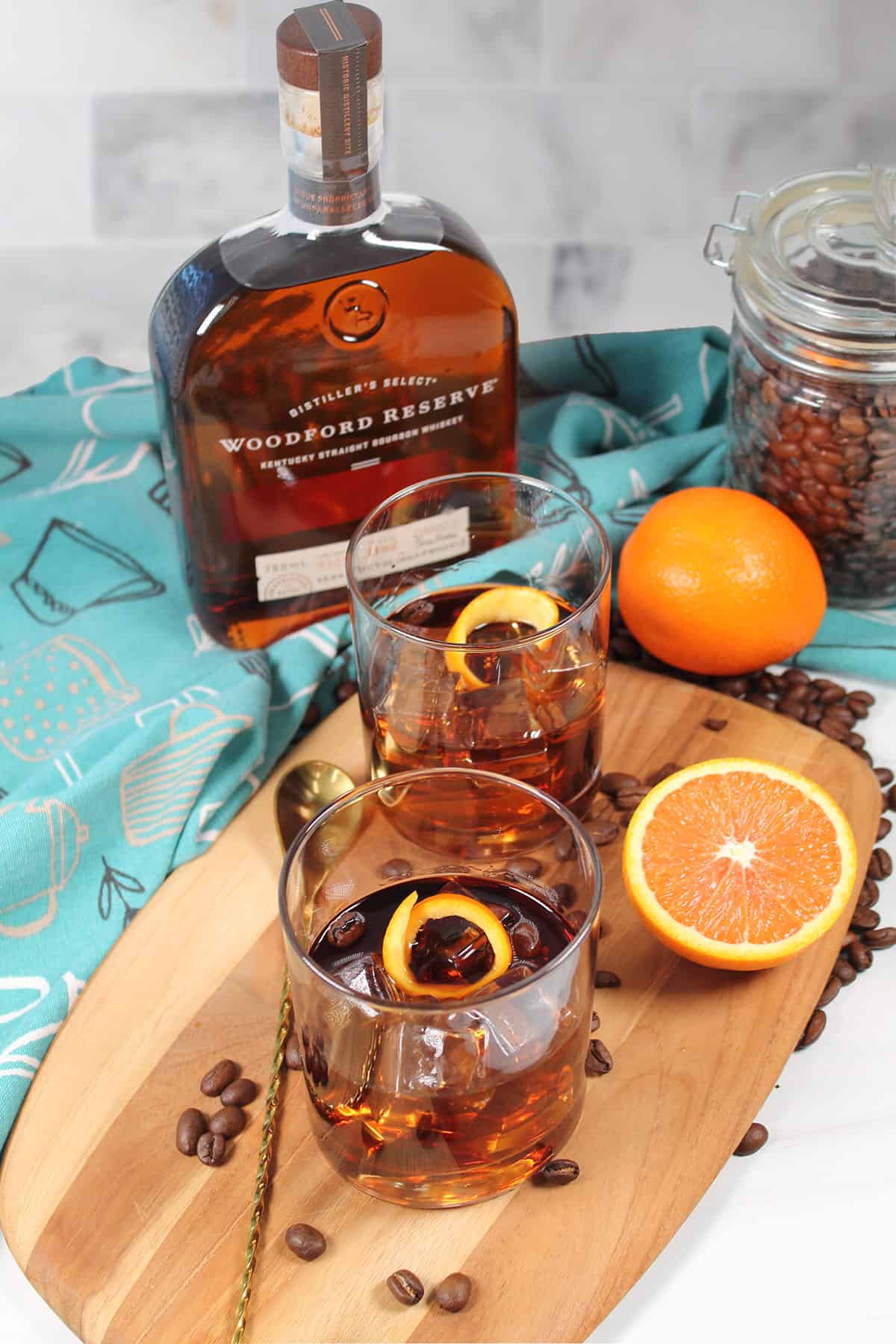 Two cocktails with bourbon bottle.