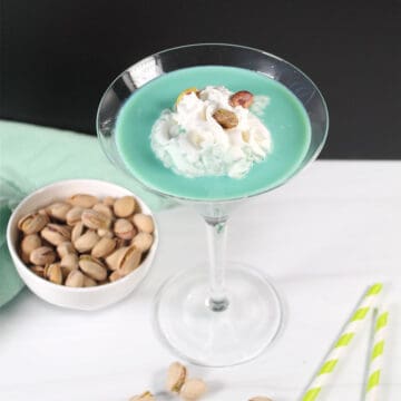 Single pistachio martini with whipped cream and pistachios.