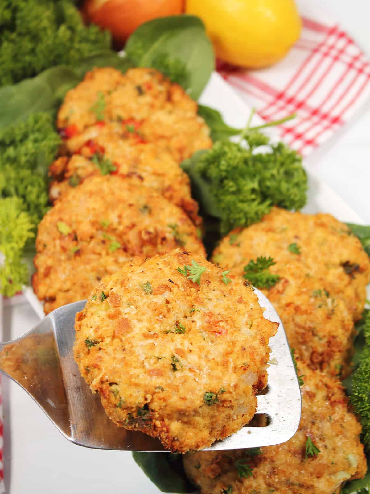 Salmon cake on spatula above platter.