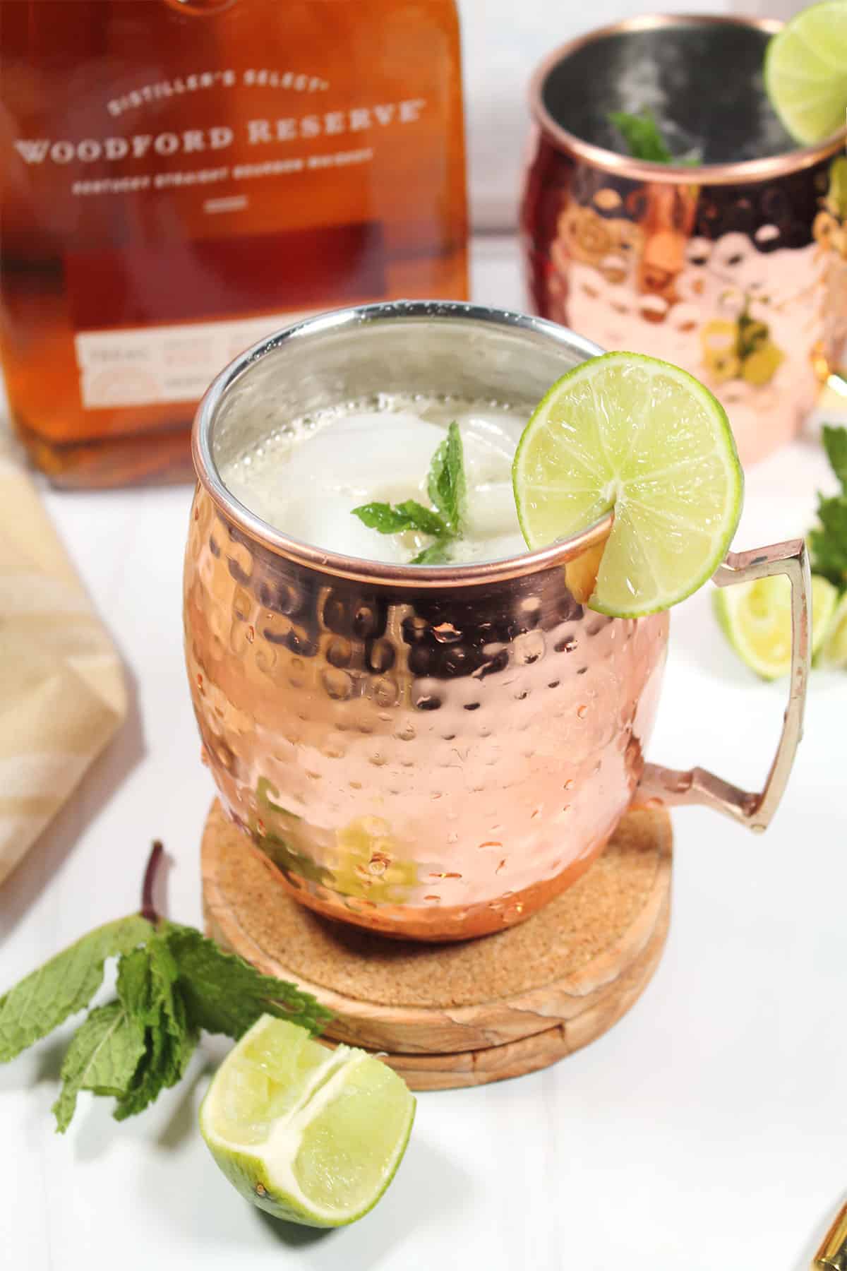 Bourbon Mule cocktail in copper mug with mint and lime garnish.