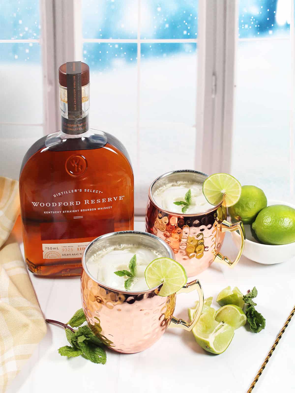 Two mule cocktails with bourbon by window.