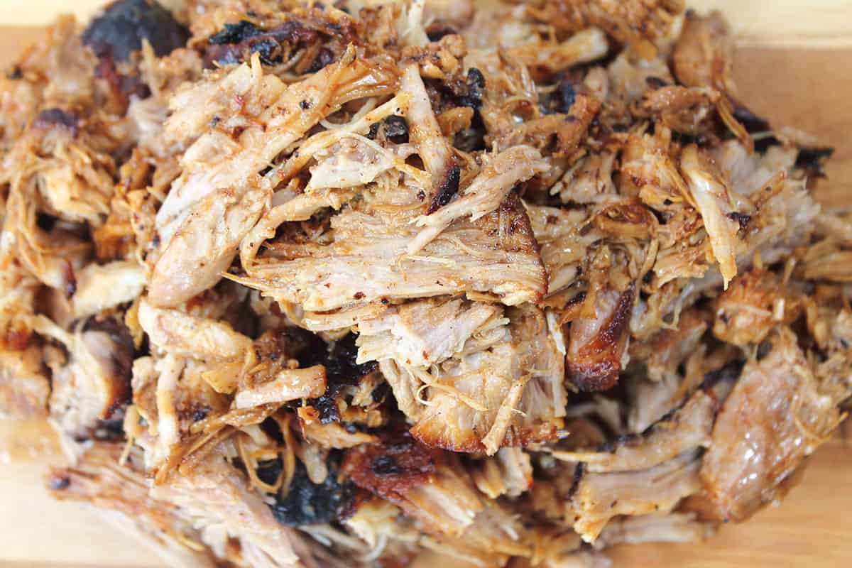 Pile of pulled pork on cutting board.