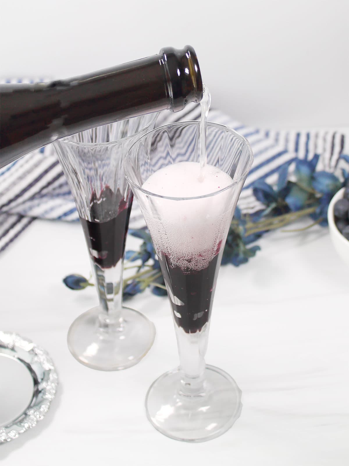 Pouring champagne over blueberry preserves.